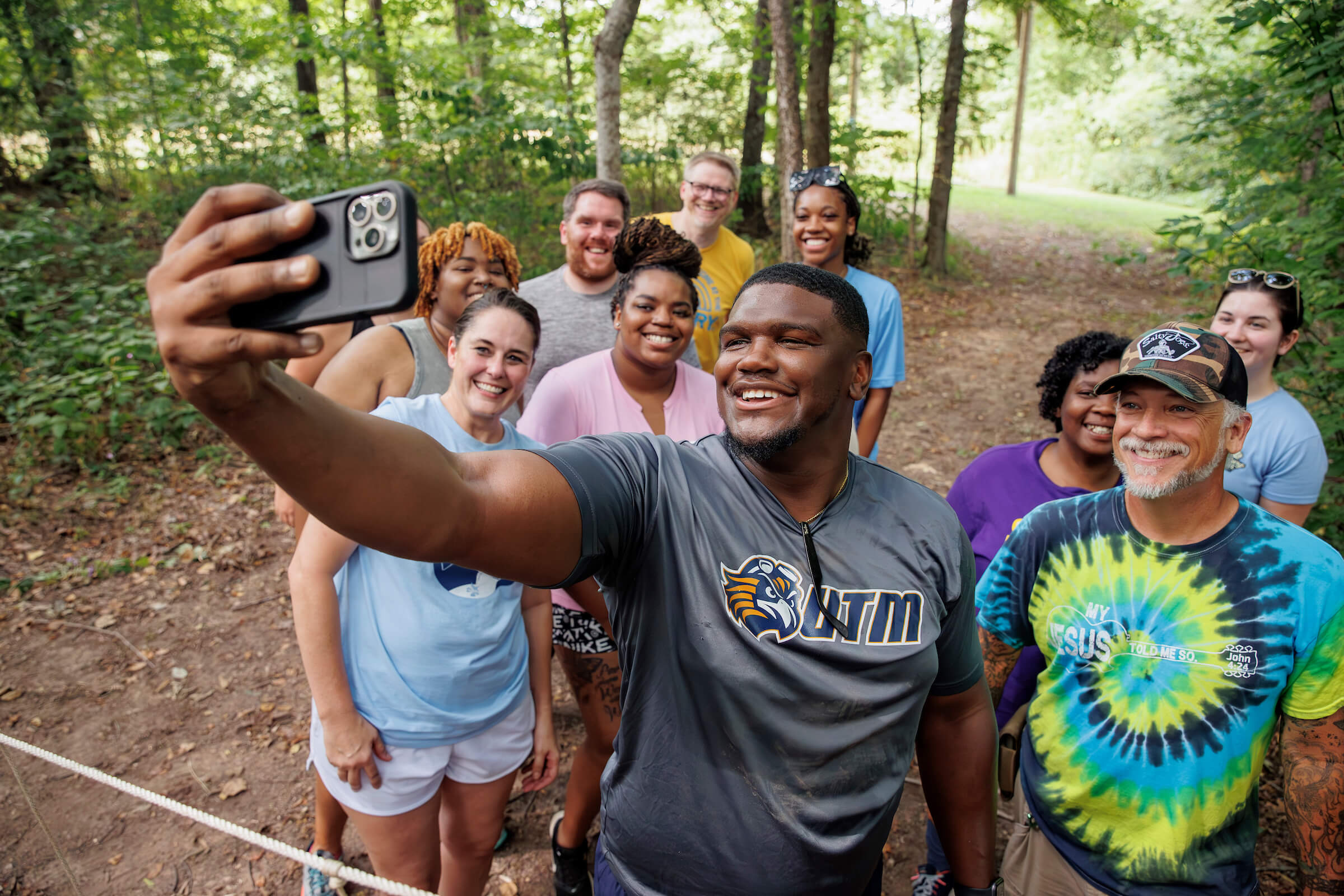 Students taking a selfie with Kameron Echols on a hiking trail.